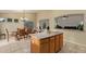 Open-concept floor plan with island, dining table and chairs in neutral color palette at 136 N 236Th Ave, Buckeye, AZ 85396