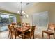 Comfortable dining room boasts natural light, an elegant chandelier, and a spacious table at 136 N 236Th Ave, Buckeye, AZ 85396