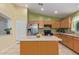 Functional kitchen with stainless steel refrigerator, central island, and convenient cabinet space at 136 N 236Th Ave, Buckeye, AZ 85396