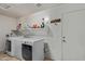 The well-equipped laundry room features a washer, dryer, and storage shelves at 136 N 236Th Ave, Buckeye, AZ 85396
