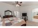 Spacious main bedroom features ceiling fan, dresser with mirror, tv and neutral walls at 136 N 236Th Ave, Buckeye, AZ 85396