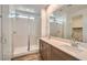 Modern bathroom with a double vanity, walk-in shower with glass door, and ample lighting at 15760 W Pioneer St, Goodyear, AZ 85338