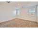 Well-lit bedroom with plush carpeting and two bright windows at 15760 W Pioneer St, Goodyear, AZ 85338