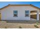 Home exterior showing two windows, stucco, and a desert landscaped rock yard at 15760 W Pioneer St, Goodyear, AZ 85338