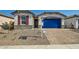 Charming single-story home with stone accents, red shutters, a blue garage door and a paver driveway at 15760 W Pioneer St, Goodyear, AZ 85338