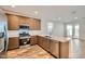 Modern kitchen with stainless steel appliances, a breakfast bar, and sleek countertops at 15760 W Pioneer St, Goodyear, AZ 85338