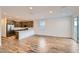 Open-concept living room and kitchen with hardwood floors, stainless steel appliances, and natural light at 15760 W Pioneer St, Goodyear, AZ 85338