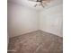 Cozy carpeted bedroom featuring a ceiling fan and double door closet at 16115 W Acacia Ct, Surprise, AZ 85374
