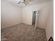 Carpeted bedroom with ceiling fan and a closet with open doors at 16115 W Acacia Ct, Surprise, AZ 85374