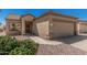 Tan home featuring desert landscaping and a two-car garage at 16115 W Acacia Ct, Surprise, AZ 85374