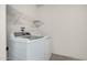 Bright laundry room with white washer and dryer and wire shelving for storage at 16115 W Acacia Ct, Surprise, AZ 85374