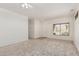 Bright living room with neutral carpet, ceiling fan and window for natural light at 16115 W Acacia Ct, Surprise, AZ 85374