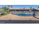 A fenced-in backyard offers a pool and a covered patio with lush palm trees at 1620 N 72Nd Ln, Phoenix, AZ 85035