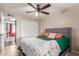 Bedroom features a ceiling fan, tile floors, natural light, and grey furniture at 1620 N 72Nd Ln, Phoenix, AZ 85035