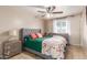 Bedroom features a ceiling fan, tile floors, natural light, and grey furniture at 1620 N 72Nd Ln, Phoenix, AZ 85035