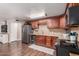 Kitchen features wood-look floors, granite countertops, brown cabinets, and stainless steel appliances at 1620 N 72Nd Ln, Phoenix, AZ 85035