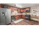 Kitchen features wood-look floors, granite countertops, refrigerator, and built-in wine cooler at 1620 N 72Nd Ln, Phoenix, AZ 85035