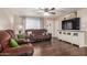 Spacious living room with plush reclining sofa, ceiling fan, and a large screen television at 1620 N 72Nd Ln, Phoenix, AZ 85035