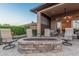 Inviting back patio area with comfortable seating around a stone fire pit, perfect for outdoor relaxation at 16422 W Alvarado Dr, Goodyear, AZ 85395