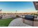 Backyard outdoor kitchen, grill and counter area with view of the community golf course and desert landscape at 16422 W Alvarado Dr, Goodyear, AZ 85395
