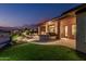 Backyard with built-in grill, patio, fire pit, pond and desert landscaping at 16422 W Alvarado Dr, Goodyear, AZ 85395