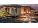 Attractive front yard showcasing desert landscaping, subtle lighting, and a pathway to the front door at 16422 W Alvarado Dr, Goodyear, AZ 85395