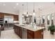 Open kitchen with granite island, stainless appliances, and adjacent dining area at 16422 W Alvarado Dr, Goodyear, AZ 85395