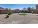 Large backyard has rock landscaping, an outdoor grill area, and an artificial grass area at 1673 S 218Th Ave, Buckeye, AZ 85326