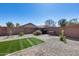 Charming backyard with gravel, artificial grass, brick pavers, and a stone fence at 1673 S 218Th Ave, Buckeye, AZ 85326