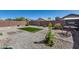 The backyard features rock landscaping, brick paver accents, and an artifical lawn at 1673 S 218Th Ave, Buckeye, AZ 85326