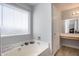 Bright bathroom showcasing the jetted tub with large sunny window at 1673 S 218Th Ave, Buckeye, AZ 85326