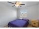 Cozy bedroom with a ceiling fan and window overlooking the backyard at 1673 S 218Th Ave, Buckeye, AZ 85326