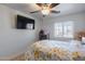 Spacious bedroom with a queen-size bed, ceiling fan, and a view from the window at 1673 S 218Th Ave, Buckeye, AZ 85326