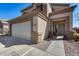 A well-maintained home exterior with a clean garage door, a tidy walkway, and desert landscaping at 1673 S 218Th Ave, Buckeye, AZ 85326