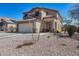 Charming two-story home with a neutral-colored exterior, low-maintenance landscaping, and attached two-car garage at 1673 S 218Th Ave, Buckeye, AZ 85326