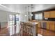 Bright kitchen featuring stainless steel appliances, wood cabinets, and an island with pendant lighting at 1673 S 218Th Ave, Buckeye, AZ 85326
