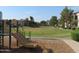 Well-maintained community playground with a slide and an expansive grassy area for recreational activities at 1941 S Pierpont Dr # 2082, Mesa, AZ 85206