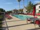 Inviting community pool with red lounge chairs, umbrellas and palm trees creating a serene resort-style environment at 1941 S Pierpont Dr # 2082, Mesa, AZ 85206