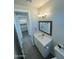 Clean bathroom featuring a quartz countertop, framed mirror and wood-look flooring at 22113 W Laura St, Wittmann, AZ 85361
