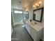 Bright bathroom featuring double vanity, modern lighting, and decorative mirror frames at 22113 W Laura St, Wittmann, AZ 85361