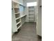 Organized walk-in closet with white shelving and ample storage space, perfect for organization at 22113 W Laura St, Wittmann, AZ 85361