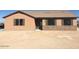Charming single-story home featuring neutral siding, shuttered windows, and a desert landscape at 22113 W Laura St, Wittmann, AZ 85361