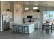Well-lit kitchen featuring white cabinetry, stainless steel appliances, and an island with barstool seating at 22113 W Laura St, Wittmann, AZ 85361