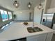 Large kitchen island with quartz countertop, stainless steel sink, and stainless steel appliances at 22113 W Laura St, Wittmann, AZ 85361