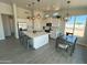 Bright kitchen boasts white cabinets, quartz countertops, stainless steel appliances, and stylish pendant lighting at 22113 W Laura St, Wittmann, AZ 85361