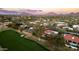 Expansive aerial view of a home on a golf course with mountain views and tile roofs at sunset at 22402 N 84Th Pl, Scottsdale, AZ 85255