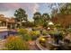 Lush backyard with a tranquil fountain, fire pit, and comfortable seating area surrounded by beautiful greenery at 22402 N 84Th Pl, Scottsdale, AZ 85255