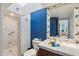 Colorful bathroom featuring a tiled shower, bright blue accent wall, and bird-themed sink and decor at 22402 N 84Th Pl, Scottsdale, AZ 85255