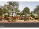 Lovely Santa Fe style home with desert landscaping, mature trees, red tile roof, and tan stucco at 22402 N 84Th Pl, Scottsdale, AZ 85255