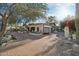 A single-story home with brick-paved drive and wrought iron entry gate is framed by mature desert landscaping at 22402 N 84Th Pl, Scottsdale, AZ 85255